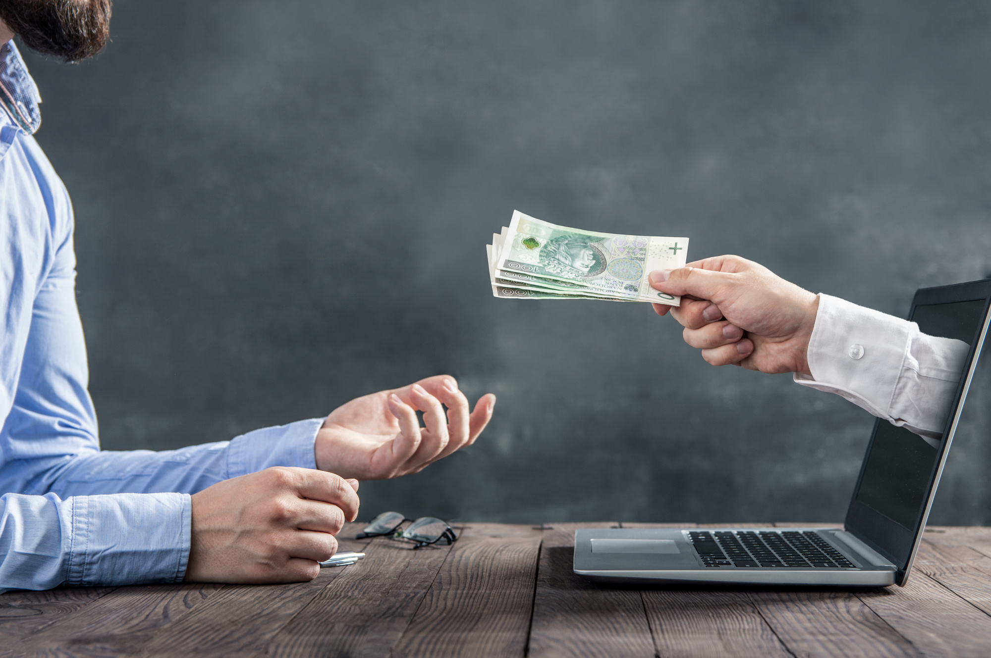 hand giving money through computer screen